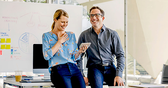 man and woman smiling in office