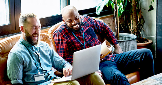 Two people reviewing things on a laptop