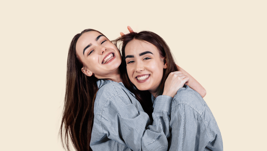 Smiling identical twin sisters