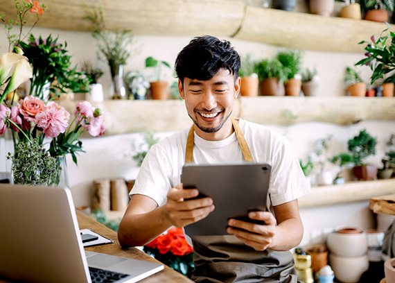 A man in a flower shop using an iPad