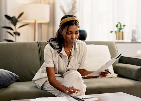 woman holding documents sitting on couch