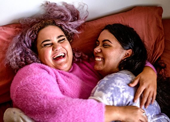 women hugging in bed