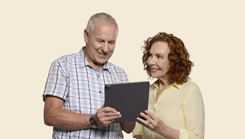 man and woman looking at iPad